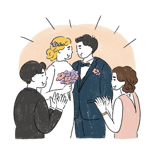 結婚式でみんなに祝福されている新郎新婦